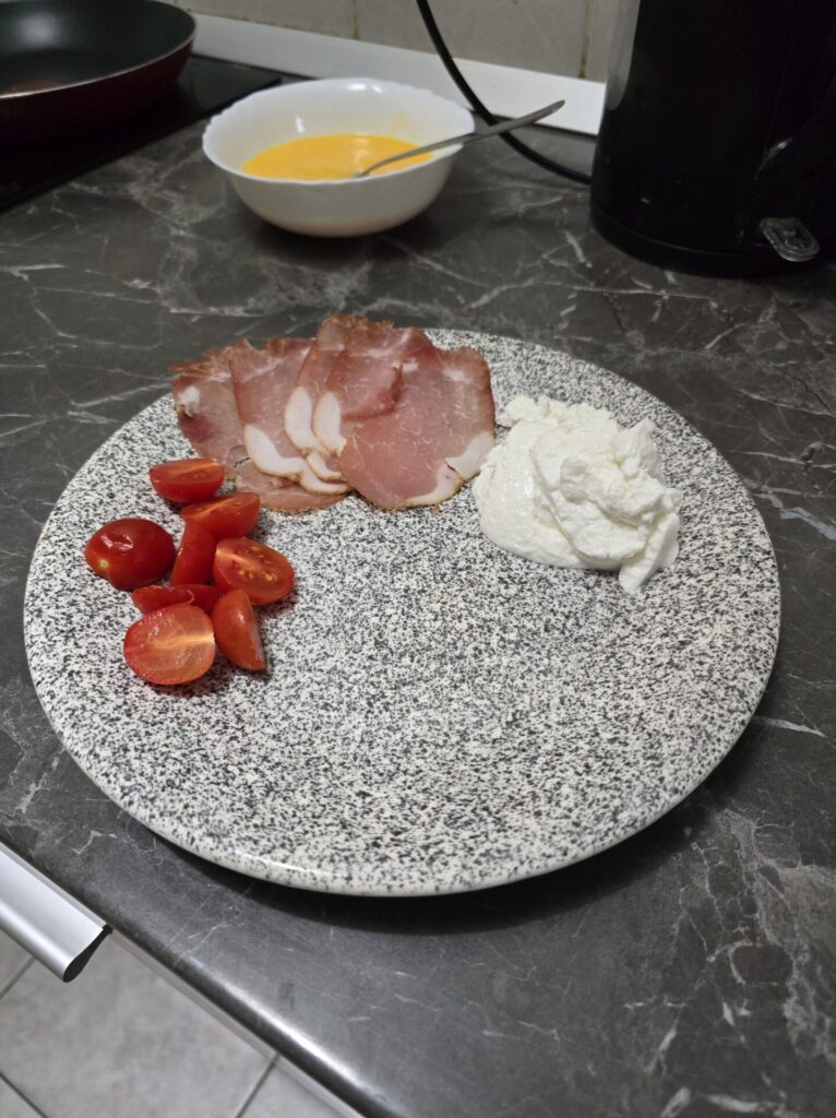 cherry tomatoes, dry cured pork loin and skyr on a plate