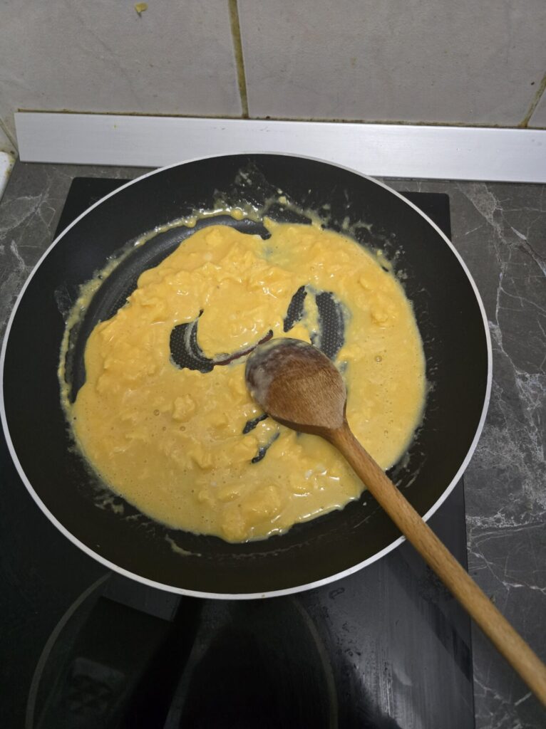 cooking creamy scrambled eggs in a pan